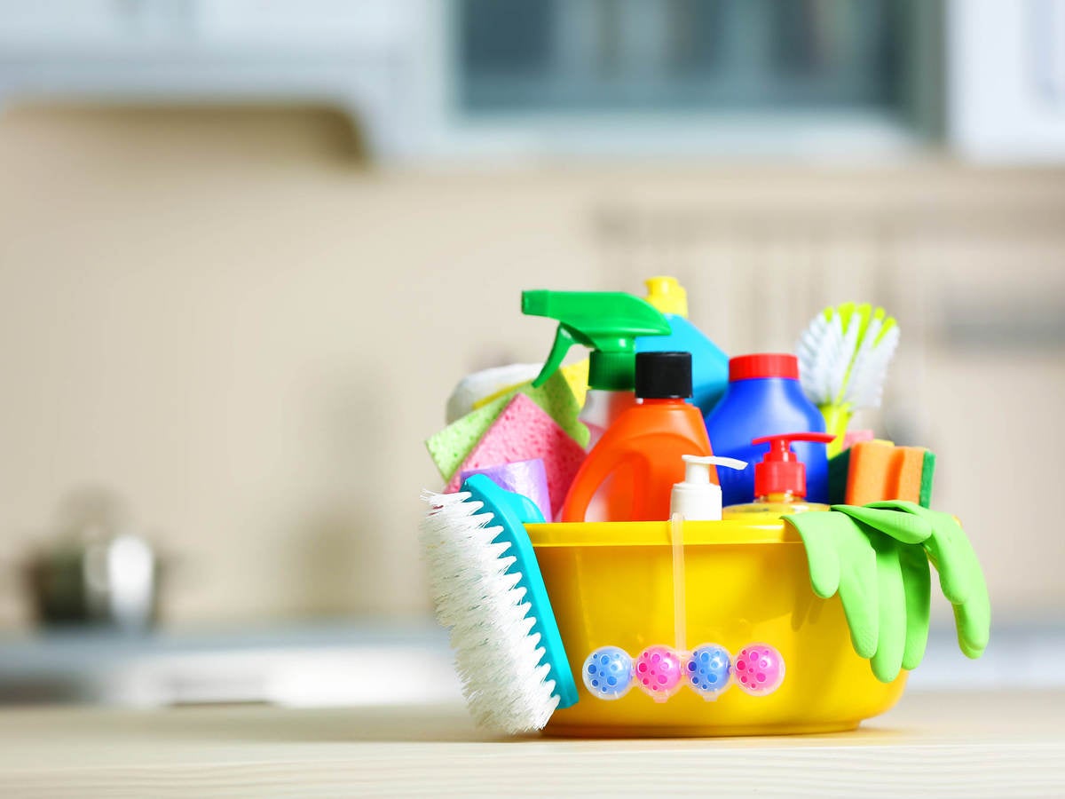 Colorful bucket filled with cleaning supplies, brush, and rubber gloves
